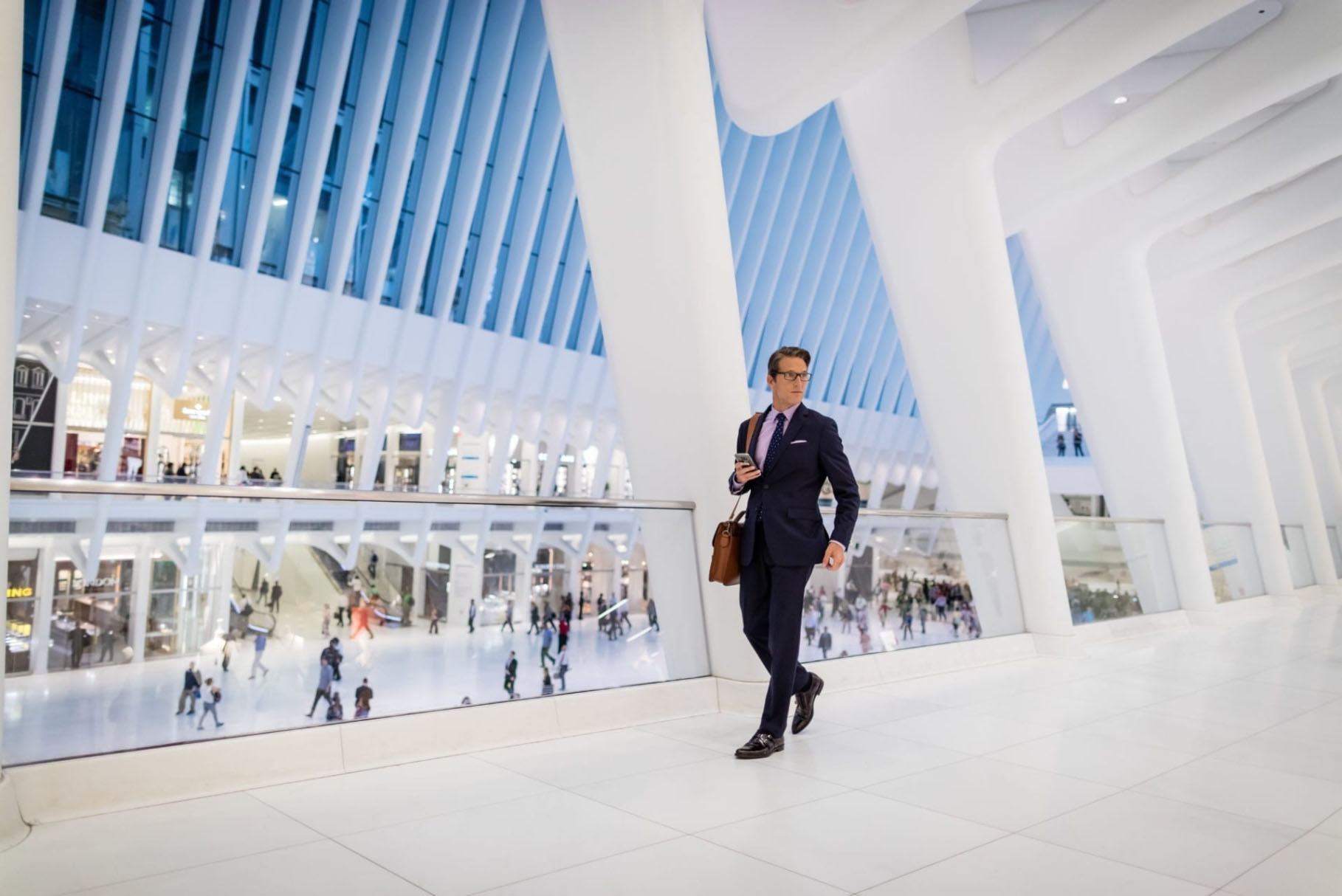 man in suit walking through oculus path station downtown