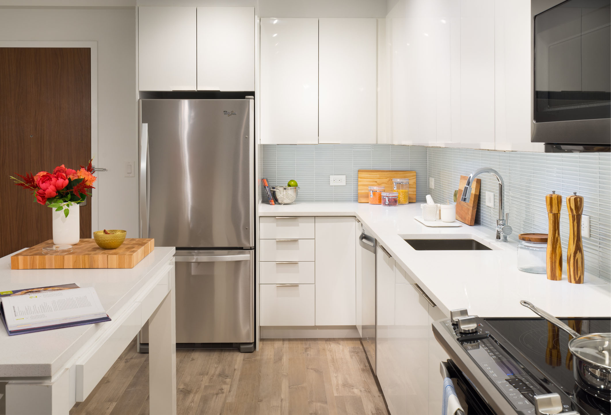 all white kitchen with stainless steel appliances in new luxury vyv