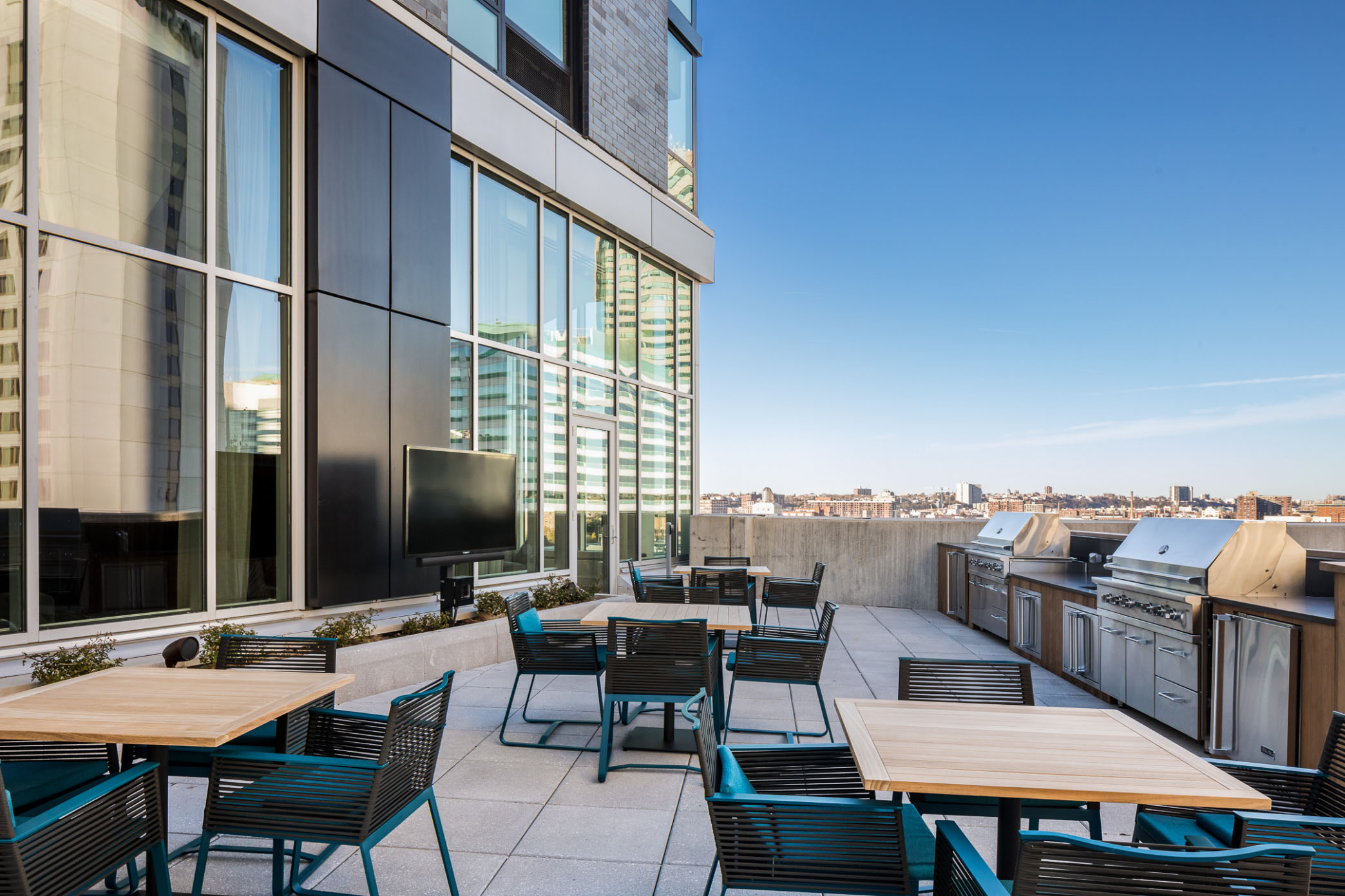 roof deck dining tables and grills overlooking jersey city hoboken